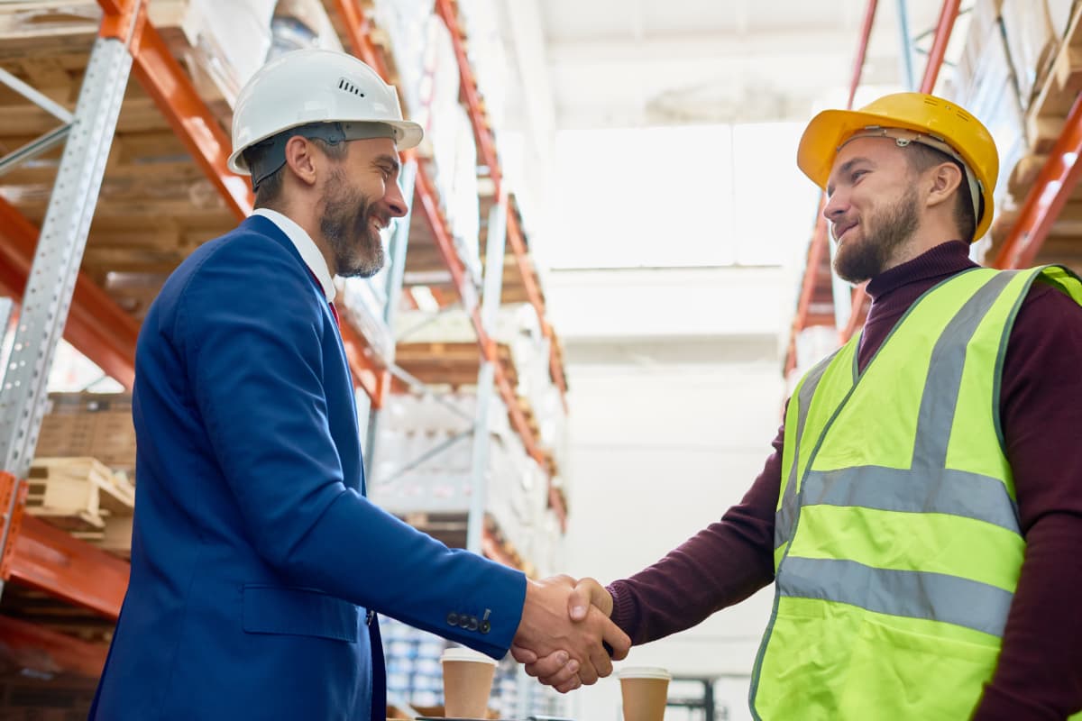 Two men shaking hands at a consturction site